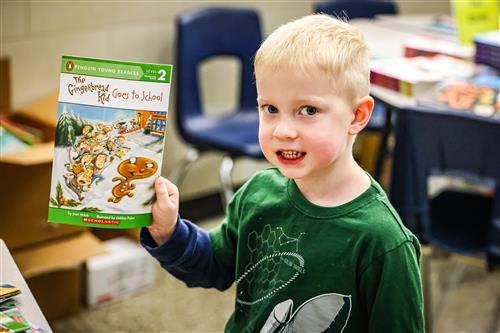 A boys holds up a book